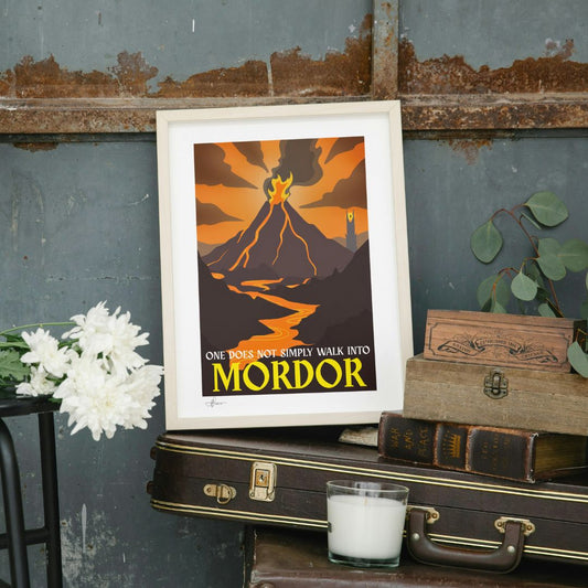 Framed poster with 'One Does Not Simply Walk into Mordor' text on a rustic surface with books and flowers.