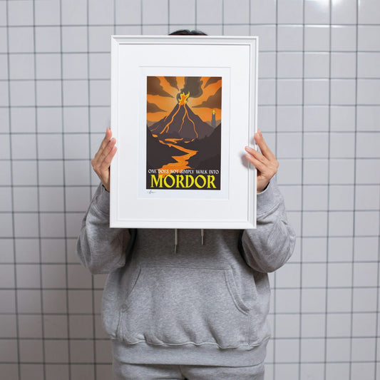 Person holding a framed poster with 'One must surely walk into Mordor' text against a tiled wall.