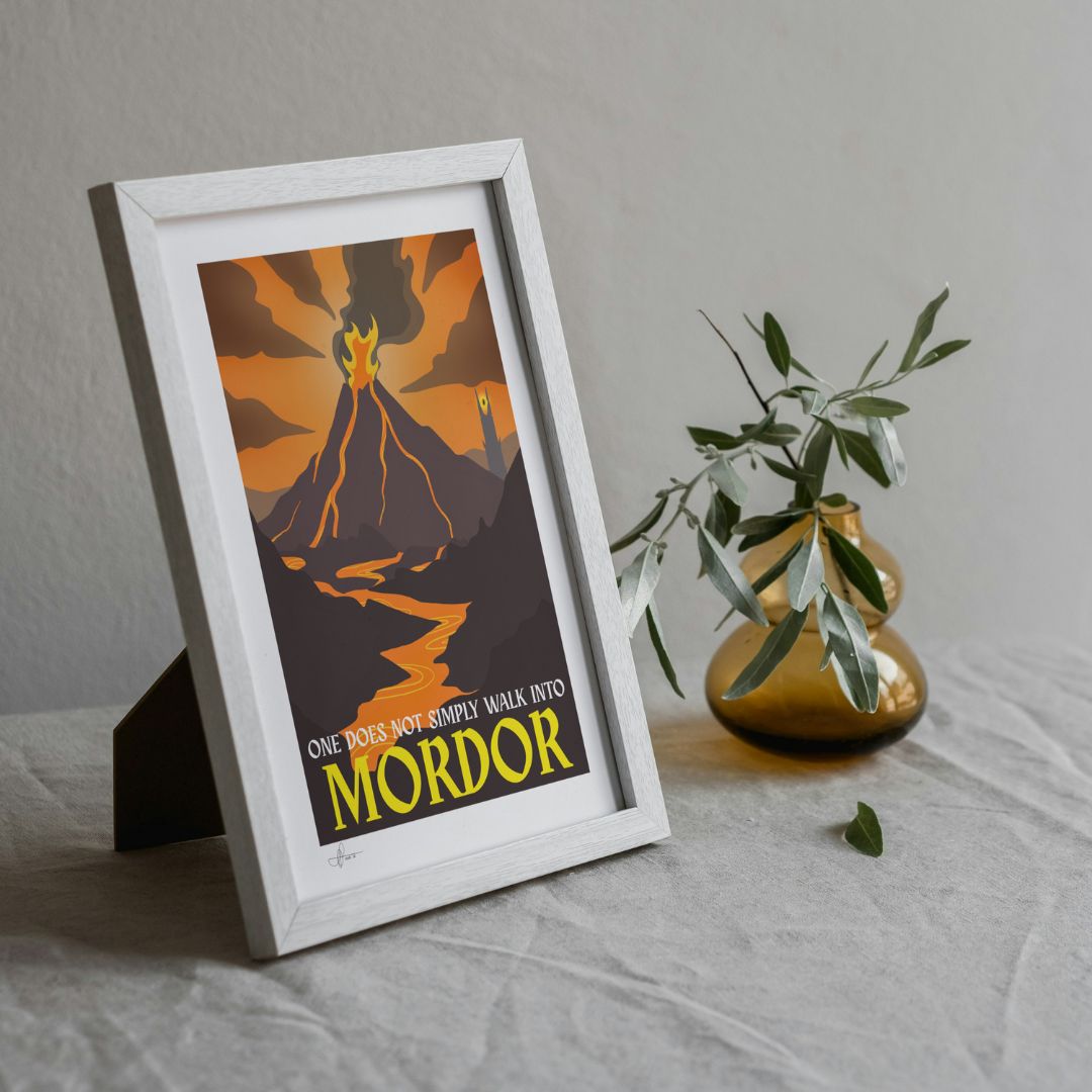 Framed poster with 'One does not simply walk into Mordor' text on a table with a plant.